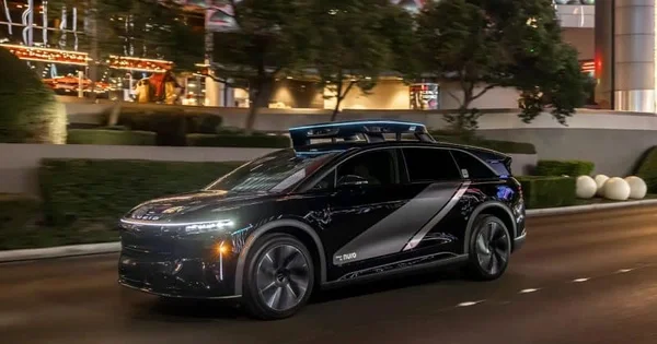 Véhicule autonome Lucid Air de GO Inc. équipé de capteurs pour robotaxis, photographié de nuit en milieu urbain.