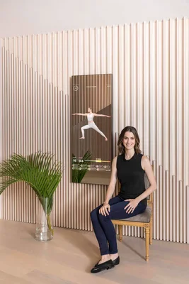 Brynn Putnam, créatrice de Mirror, posant devant son miroir de fitness connecté.