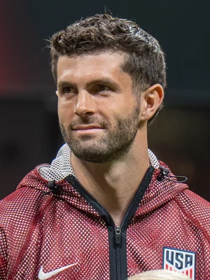 Christian Pulisic, joueur de l'équipe nationale américaine, en veste d'échauffement rouge.