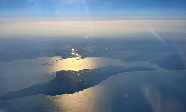 Vue aérienne de l'île d'Oléron depuis l'ouest, avec le soleil se reflétant sur l'eau.