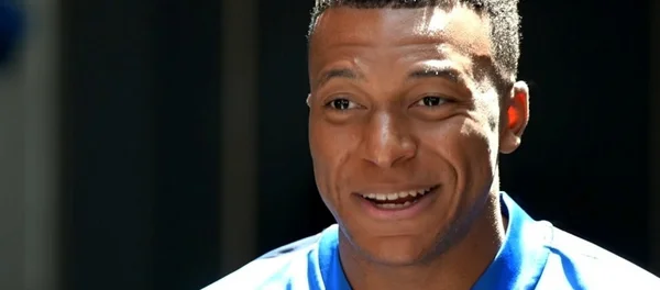 Kylian Mbappé, souriant, lors d'une interview télévisée.
