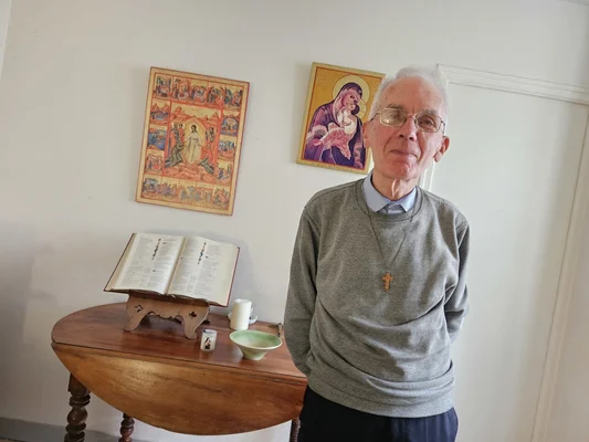 Un prêtre exorciste âgé dans son espace de prière et d'étude.