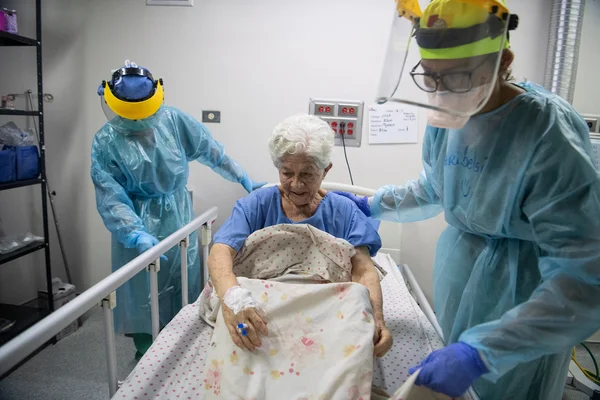 Soignants de Médecins Sans Frontières assistant une patiente âgée à l'hôpital Francisca Pérez de León II à Petare, Caracas.