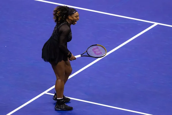 Joueuse de tennis célébrant un point sur un court dur.