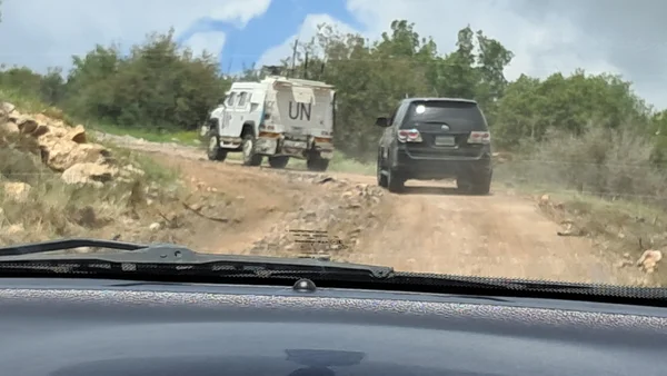 Un convoi de l'ONU et un SUV quittant une zone rurale au Liban.