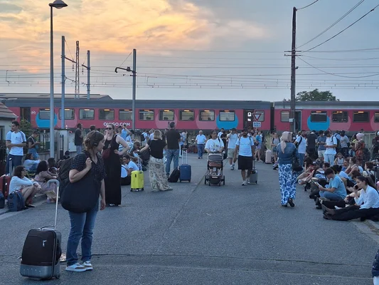 Voyageurs en attente près d'un train Ouigo immobilisé, illustration des perturbations ferroviaires.