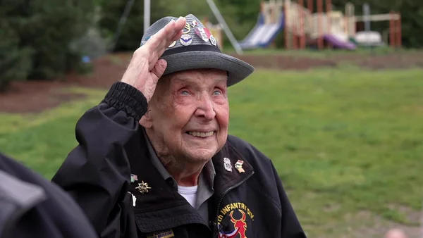 Un vétéran de la Seconde Guerre mondiale, reconnaissable à ses insignes militaires, salue lors d'une commémoration.