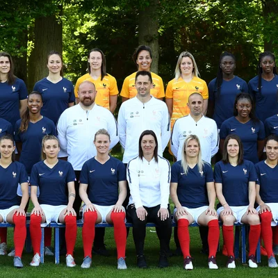 Photo officielle des Bleues pour la Coupe du Monde 2019, prise en extérieur devant un décor boisé.