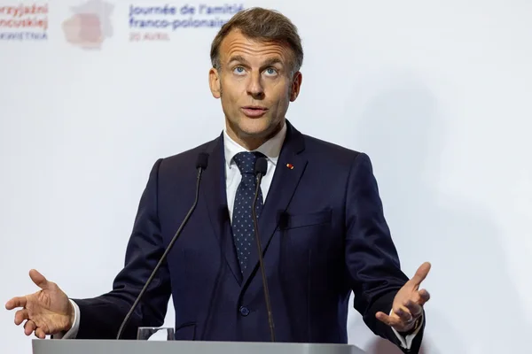 Emmanuel Macron s'exprimant à un pupitre, dans le cadre de l'amitié franco-polonaise.