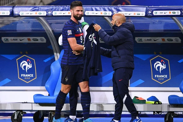 Didier Deschamps remet un maillot à Olivier Giroud lors d'un rassemblement des Bleus.