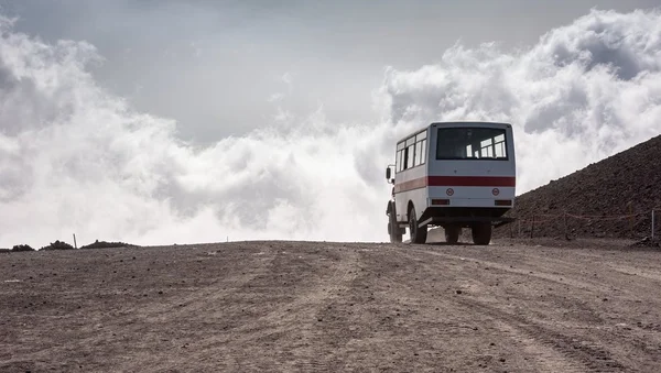 Bus blanc sur une route poussiéreuse dans un paysage aride en Éthiopie.
