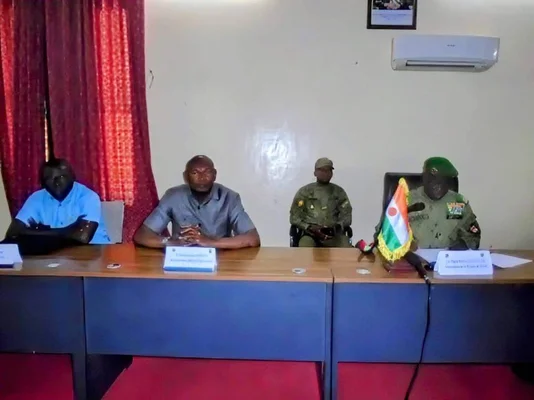 Réunion d'un comité technique avec des participants en tenue militaire et civile.