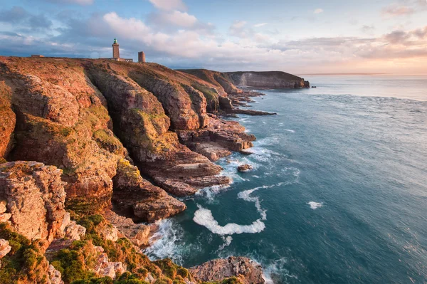 Falaises et phare emblématiques des Côtes d'Armor, destination rafraîchissante en Bretagne.