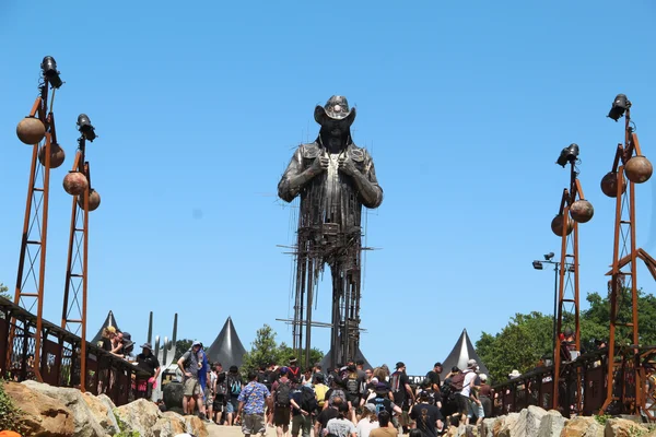 Sculpture métallique de cowboy au Hellfest, entourée de festivaliers.