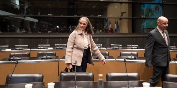 Une femme traversant une salle d'audience, illustrant le contexte budgétaire de France Télévisions.