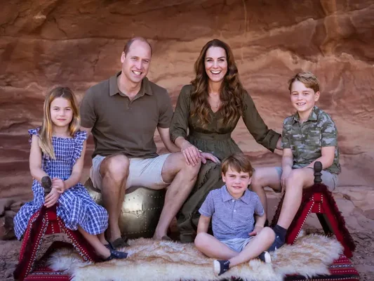 Portrait de la famille princière en extérieur sur fond de roche rouge.