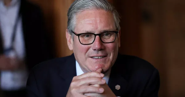 Keir Starmer, Premier ministre britannique, en costume sombre et lunettes.
