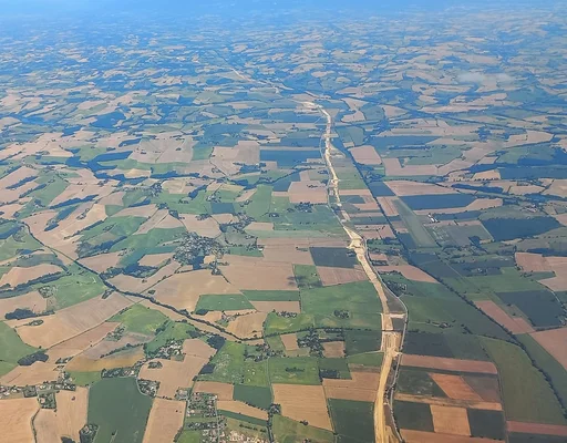 Vue aérienne du chantier de l'autoroute A69 en cours de construction à travers les terres agricoles.