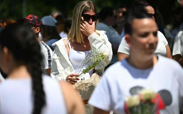 Moment d’émotion lors de la marche blanche à Fleurance pour Lyhanna, avec une participante tenant un bouquet de fleurs blanches.