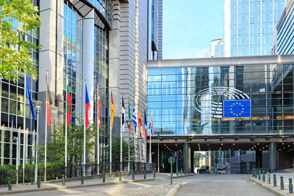 Façade du Parlement européen à Bruxelles avec les drapeaux de l'UE.