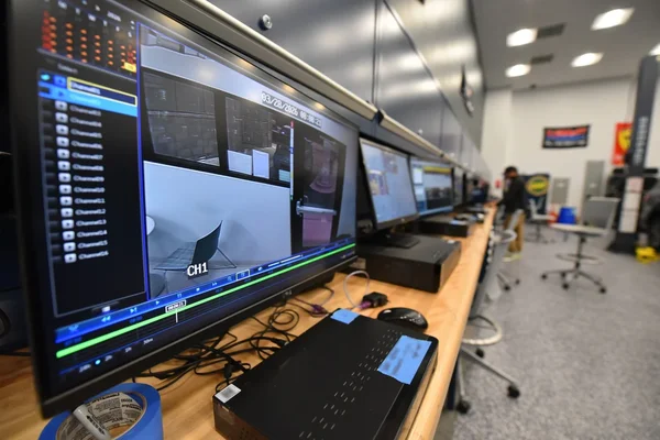 Poste de surveillance de la salle de contrôle du FBI, avec écrans de vidéosurveillance.