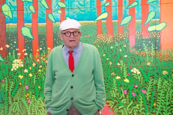 David Hockney dans son atelier, entouré de ses toiles et de son matériel de peinture.