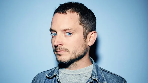 Elijah Wood en veste en jean, portrait studio.