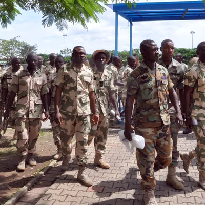 Militaires en tenue de camouflage marchant sur un chemin extérieur, illustrant les condamnations au Nigeria.