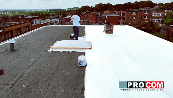 Travaux d'application de peinture blanche réflective sur une toiture plate.