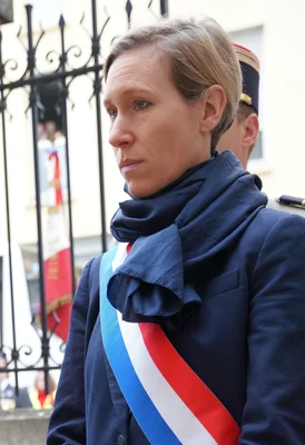 La députée Laure Miller, en manteau et écharpe tricolore, devant l'Assemblée nationale lors de l'affaire Lyhanna.