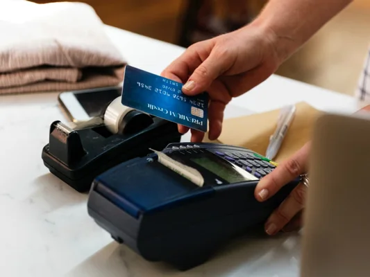 Paiement par carte bancaire bleue sur un terminal de point de vente, illustrant la montée des paiements sans espèces en Allemagne.
