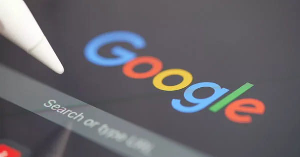 Écran affichant le logo Google et une barre de recherche, avec un stylet.