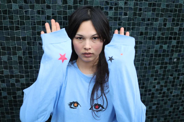 Miki dans un sweat à motifs, photographiée par Le Parisien.