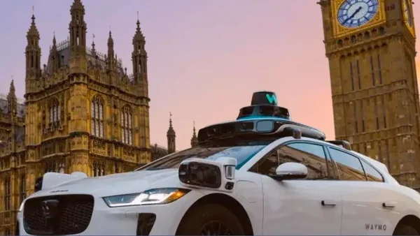 Waymo autonome devant le Parlement de Londres et Big Ben au crépuscule.