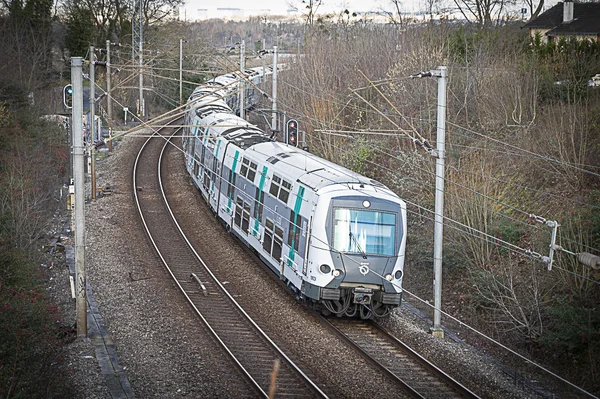 Un train de banlieue sur une voie courbe, illustrant l'infrastructure du réseau RER.