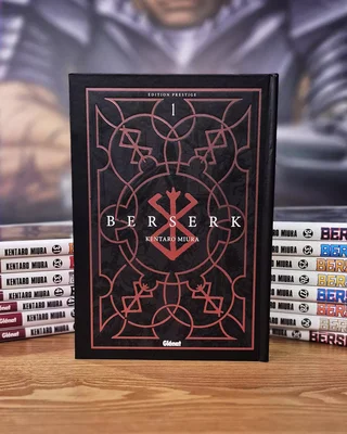 Le premier volume de l'édition Prestige de Berserk, posé à côté d'autres tomes de la série.