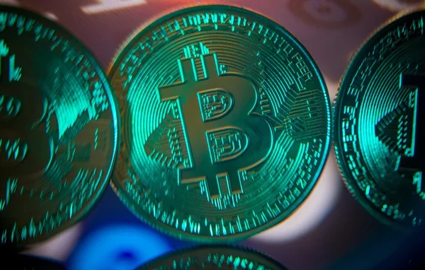 Photographie macro de pièces Bitcoin, symbole des cryptomonnaies concernées par la suspension de Binance en Europe.