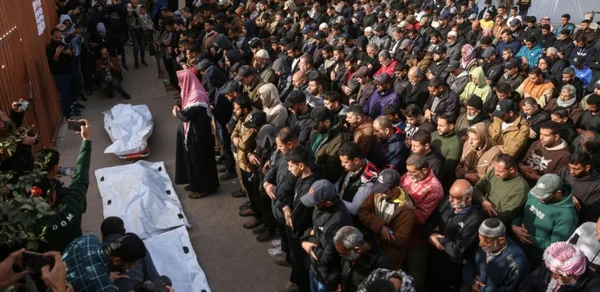 Funérailles à Gaza après des frappes israéliennes, rassemblant une foule nombreuse.
