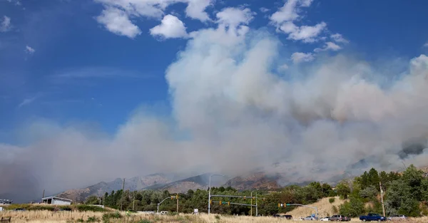 Incendie de Monroe Canyon dans l'Utah : épais panache de fumée s'élevant des pentes montagneuses.