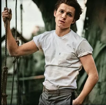 Tom Holland en tenue décontractée, tenant une corde en extérieur.