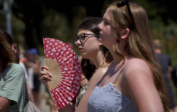 Deux jeunes femmes se protègent de la chaleur avec un éventail lors de la canicule qui frappe le sud de l'Europe.