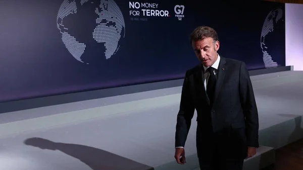 Emmanuel Macron s'exprimant lors du sommet du G7, avec l'écran 'NO MONEY FOR TERROR' en arrière-plan.