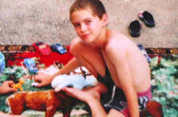 Jonathan Coulom jouant avec des jouets sur un tapis.