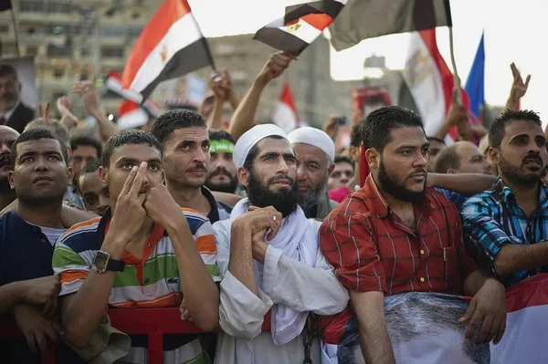 Rassemblement de partisans des Frères musulmans en Égypte, agitant des drapeaux égyptiens.