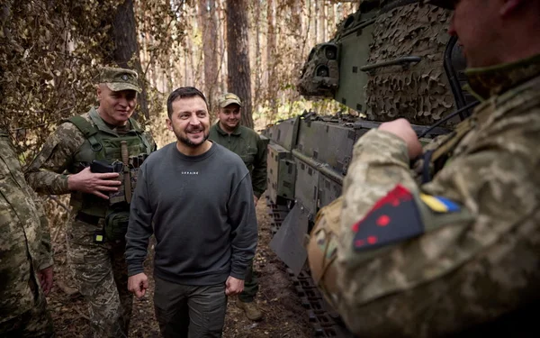 Soldats ukrainiens en patrouille dans une zone boisée.