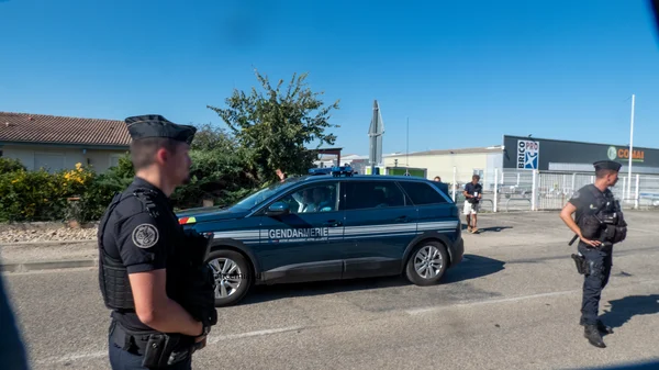 Gendarmes près de leur véhicule à Tonneins, illustrant le contexte de l'intervention.