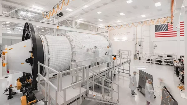 Assemblage d'un module spatial dans une salle blanche, avec des techniciens en tenue de protection.
