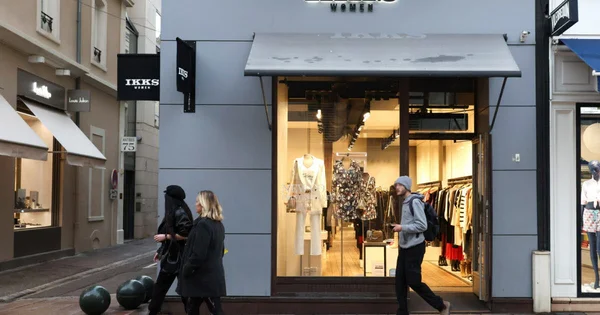 Magasin IKKS Women vu de la rue avec des passants.