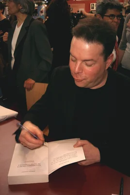 Douglas Kennedy dédicace son roman 'Les Clairs Discours de la Vie Conjugale' lors d'une séance de signature en librairie.