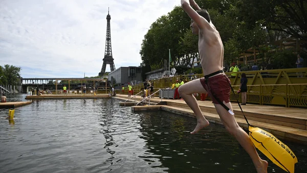Saut dans la Seine avec bouée de sécurité, tour Eiffel en arrière-plan.